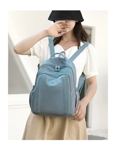 Modern light blue nylon backpack shown on model during outdoor daily commute