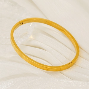 Minimalist 18k gold plated stainless steel oval bangle on white fabric background