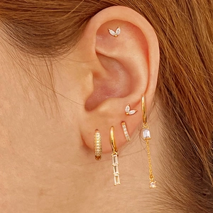 Close-up of elegant gold plated tassel earrings with sparkling zircon stones on model
