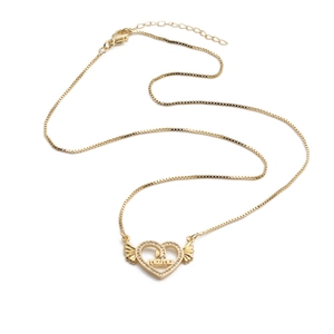 Detailaufnahme eines goldenen Herzanhängers mit Flügeln, Kristallbesatz und Mama-Gravur