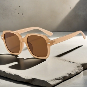 Macro detail of champagne square oversized sunglasses with silver metal studs on gray stone