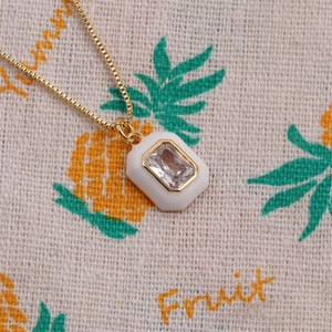 Détail du pendentif octogonal plaqué or avec cristal sur tissu à motif de fruits