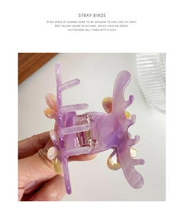 Close-up of marble purple and yellow acetate hair claw clip with golden metal spring
