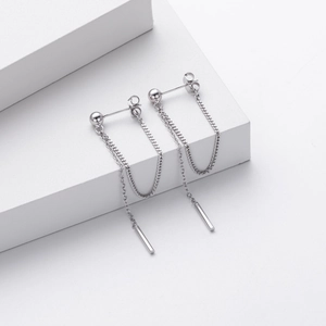 Detail of long S925 sterling silver chain earrings with sleek cylindrical pendants
