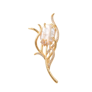 Detailed macro shot of a golden tulip brooch with baroque pearl and inlaid zircons