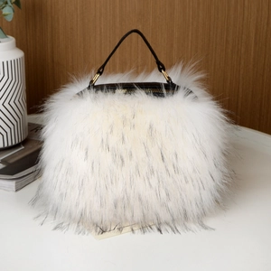 Detail of white faux fur handbag with black leather handle and gold metal ring clips