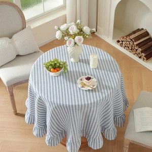 Detail of blue and white striped round tablecloth with ruffled edge in a Nordic living room