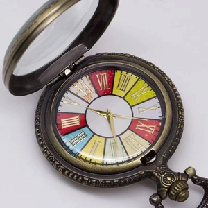 Close-up of bronze vintage pocket watch featuring colorful dial and Roman numerals