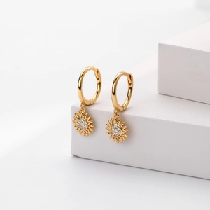 Macro detail of golden sunflower drop earrings with sparkling clear cubic zirconia