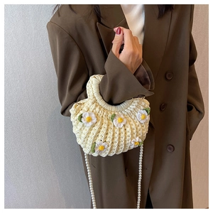 Detail of handmade cream woven bag featuring 3D daisy flowers and elegant pearl strap