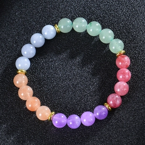 Macro detail of 8mm multicolored moonstone beads with gold spacers on black background