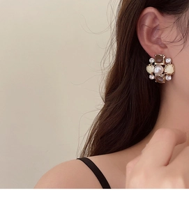 Close-up of vintage flower earrings with pearls and rhinestones on female model