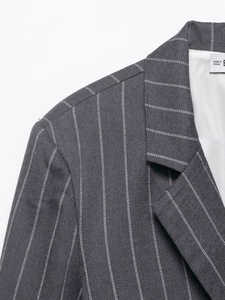 Detail of dark grey striped blazer showing high-quality twill fabric and shoulder stitching