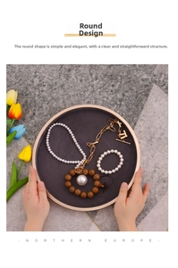 Close-up of jewelry display tray featuring pearl necklaces and gold chains on marble