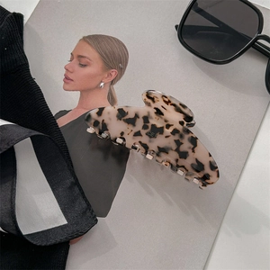 Close-up of a large tortoiseshell acetate hair claw clip on a fashion magazine