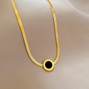 Detail of gold titanium steel Roman numeral pendant on flat snake chain necklace