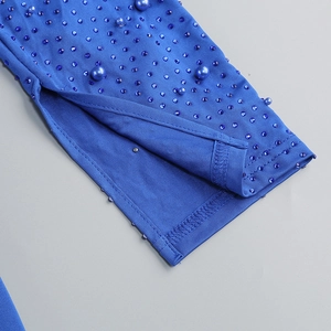 Close-up of sleeve hem featuring side slit, blue rhinestones and pearl embellishments