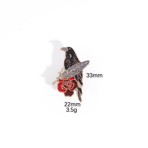 Detailed enamel pin view showing a black crow, red rose, and feather with 33mm dimensions