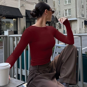 Dettaglio del top aderente rosso scuro a maniche lunghe con schiena scoperta alla moda