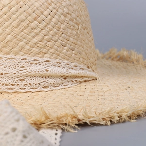 Pastoral straw sun hat with lace ribbon and frayed edges for beach vacation