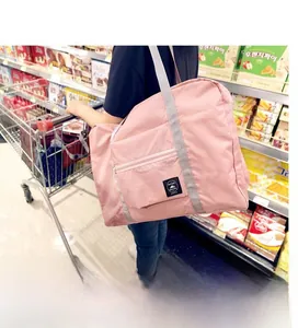 Pink foldable large capacity travel bag used as a shopping tote in a supermarket aisle