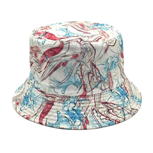 Detailed view of red and blue abstract marble print on a white cotton bucket hat