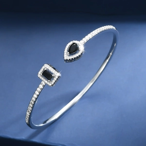 Detail of adjustable silver bracelet with pear and rectangular black gemstones and halo crystals