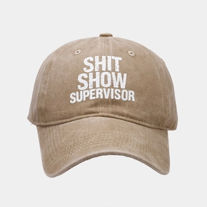 Detail of washed khaki cotton baseball cap with Shit Show Supervisor embroidery