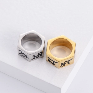 Macro shot of silver and gold hexagonal stainless steel rings with engraved Sanskrit