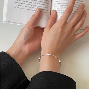 Close-up of minimalist S925 sterling silver beaded elastic bracelet on a woman wrist