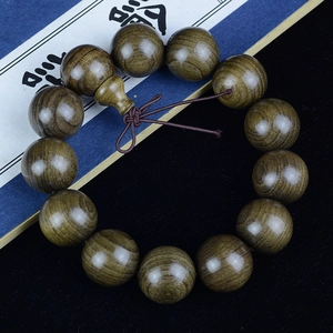 Polished natural Phoebe zhennan wood prayer beads with decorative knot on vintage book