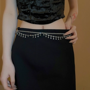 Detail of double-layer silver waist chain with shimmering rhinestone tassels on a model
