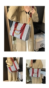 Detail of grey-blue woven tote with red fabric straps and golden curved handle