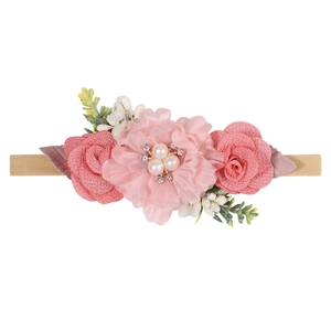 Detail of soft nylon baby headband with pink fabric flowers and faux pearls