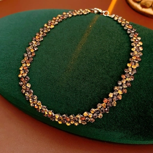 Gros plan d'un collier en cristal ambré sur fond de velours vert luxueux