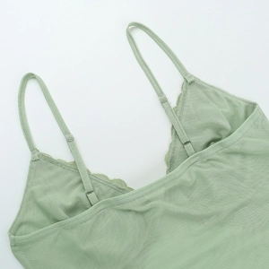 Detail of adjustable straps and floral lace trim on light green V-neck camisole top