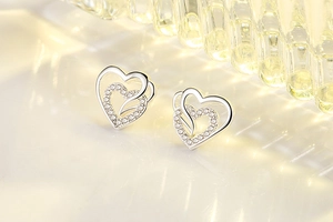 Detailed macro view of interlocking double heart stud earrings with sparkling cubic zirconia