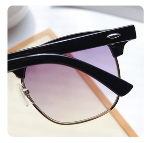 Macro view of retro Clubmaster sunglasses with purple gradient lenses and gold metal details