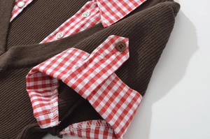 Detail of brown knit dress featuring contrast red and white plaid polo collar and cuffs