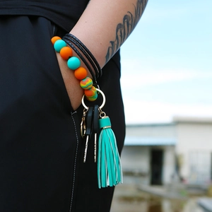 Silicone beaded wristlet keychain with turquoise tassel and golden ring on wrist