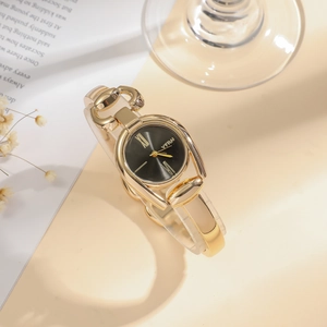 Detailed view of women's vintage quartz watch with gold metal band and black Roman dial