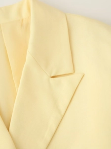Détail de la veste jaune clair montrant le col à revers et la texture du sergé