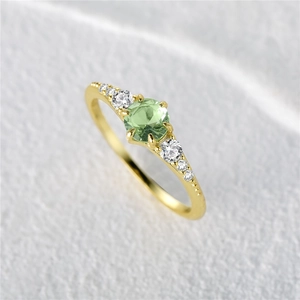Macro shot of 925 silver ring featuring round green gemstone and side zircon accents