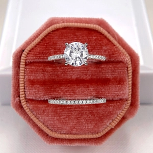 Macro shot of a brilliant round moissanite engagement ring and micro-pave band set