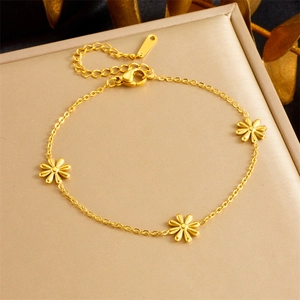Minimalistisches vergoldetes Gänseblümchen-Armband mit drei Blumenanhängern auf goldenem Grund
