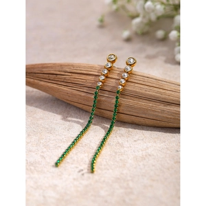 Macro detail of 18k gold stainless steel tassel earrings with green and white zircons