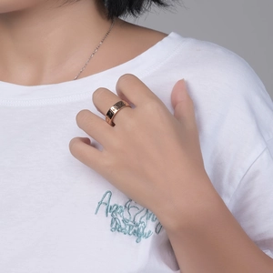 Minimalist rose gold stainless steel ring with Roman numerals on a model's hand
