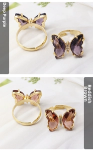 Detail view of adjustable butterfly rings with purple and reddish brown crystals
