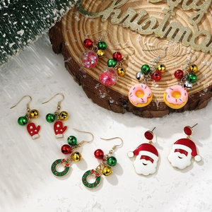 Five pairs of festive Christmas earrings including Santa Claus and bells on wooden base