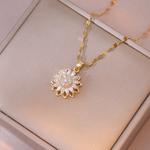 Detailed view of rotating sunflower pendant necklace with zircon crystals on jewelry box